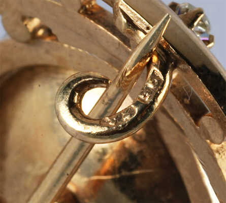 Брошь из желтого металла, общим весом 23,2 грамма, содержит природные вставки: изумруд и бриллианты